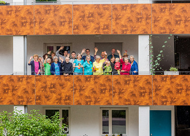 Gemeinschaftliche Wohnprojekte Menschen winken vom Balkon aus