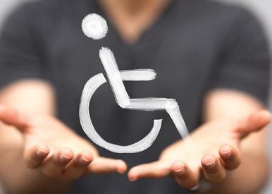 Rollstuhlfahrersymbol gehalten von 2 Händen