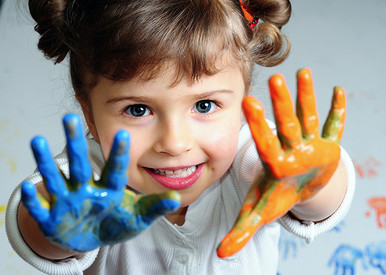 Mädchen mit blau und orange gefärbter Hand