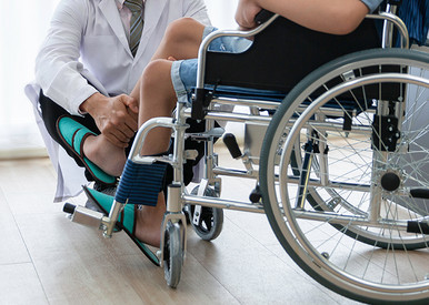 Arzt untersucht Patient im Rollstuhl