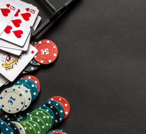 Spielkarten und Pokerchips liegen zerstreut auf einem Tisch 