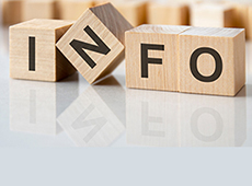 four wooden blocks with the letters info on the bright surface of a gray table. the inscription on the cubes is reflected from the surface of the table