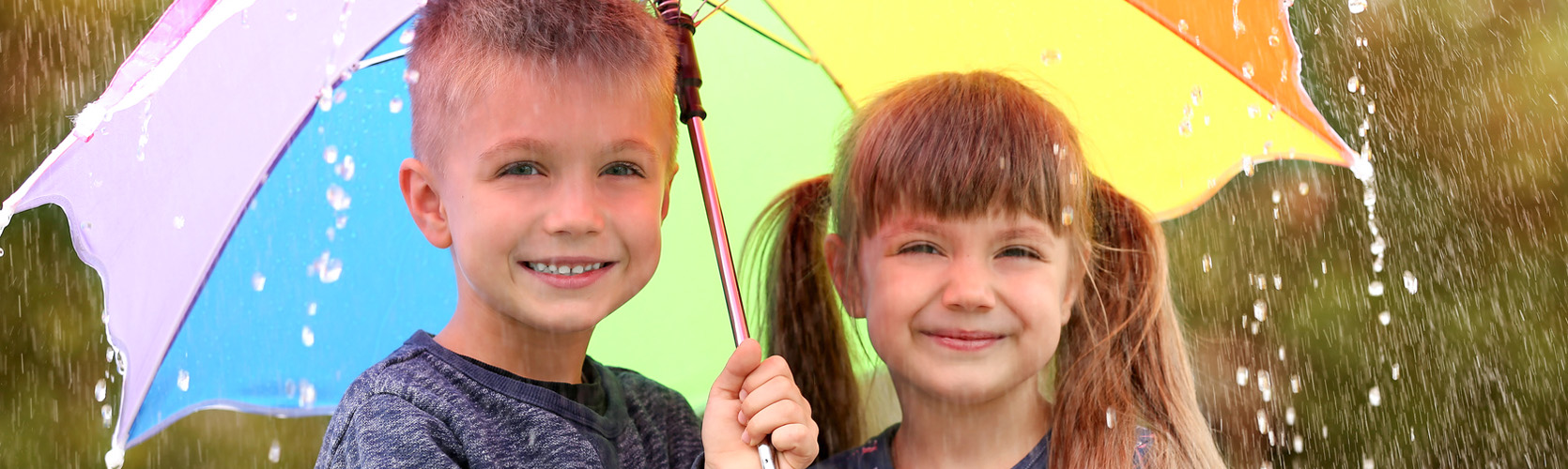 Zwei Kinder unterm Regenschirm